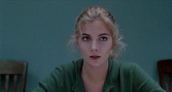 Movie still from “Patty Hearst” (1988), directed by Paul Schrader – A woman with a green shirt is posing for a picture; Close Up shot, High angle