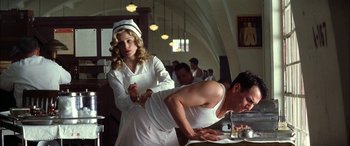 Movie still from “Pearl Harbor” (2001), directed by Michael Bay – A woman standing next to a man on a table; Medium shot, Low angle