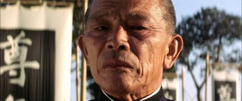 Movie still from “Pearl Harbor” (2001), directed by Michael Bay – An older man wearing a priest's outfit; Close Up shot, Low angle