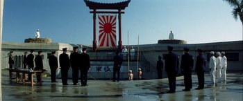 Movie still from “Pearl Harbor” (2001), directed by Michael Bay – A group of men standing around a building; Extreme Wide shot, Low angle