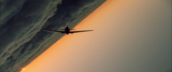 Movie still from “Pearl Harbor” (2001), directed by Michael Bay – An airplane is flying in the sky during the sunset; Extreme Wide shot, Low angle