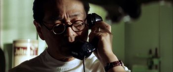 Movie still from “Pearl Harbor” (2001), directed by Michael Bay – A man in glasses is talking on a black phone; Close Up shot, Low angle