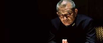 Movie still from “Pearl Harbor” (2001), directed by Michael Bay – An older man in a black suit looking at the camera; Close Up shot, Low angle