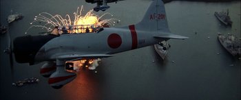 Movie still from “Pearl Harbor” (2001), directed by Michael Bay – An airplane is flying through the air with a bunch of fire coming out of it; Extreme Wide shot, High angle
