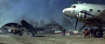 Movie still from “Pearl Harbor” (2001), directed by Michael Bay – An airplane is on the ground with smoke coming from it; Wide shot, Low angle