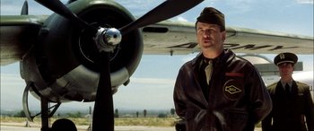 Movie still from “Pearl Harbor” (2001), directed by Michael Bay – A man standing in front of an old airplane; Medium shot, Low angle