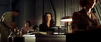 Movie still from “Pearl Harbor” (2001), directed by Michael Bay – A woman sitting at a desk in front of a bunch of lights; Medium shot, Low angle