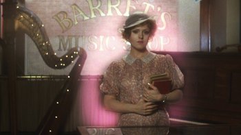 Movie still from “Pennies from Heaven” (1981), directed by Herbert Ross – A woman holding a book in her hands; Wide shot, High angle