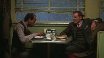 Movie still from “Pennies from Heaven” (1981), directed by Herbert Ross – Two men sitting at a table in front of plates of food; Medium shot, Low angle
