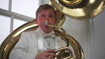 Movie still from “Pennies from Heaven” (1981), directed by Herbert Ross – A boy in a white tuxedo playing a tuba; Medium shot, Low angle
