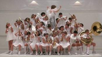 Movie still from “Pennies from Heaven” (1981), directed by Herbert Ross – A large group of people in white outfits playing musical instruments; Wide shot, High angle
