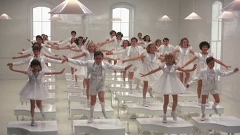 Movie still from “Pennies from Heaven” (1981), directed by Herbert Ross – A group of people in white dresses standing on white chairs; Wide shot, High angle