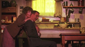 Movie still from “Pennies from Heaven” (1981), directed by Herbert Ross – A man and a woman sitting at a kitchen table; Medium shot, Low angle