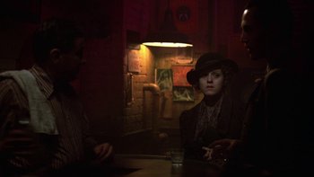 Movie still from “Pennies from Heaven” (1981), directed by Herbert Ross – A woman sitting at a table in a dark room; Medium shot, Over the shoulder angle