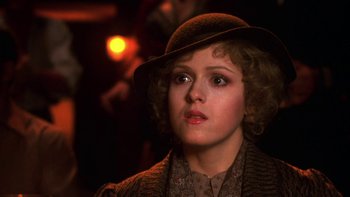 Movie still from “Pennies from Heaven” (1981), directed by Herbert Ross – A young woman wearing a brown hat and a brown coat; Close Up shot, Over the shoulder angle