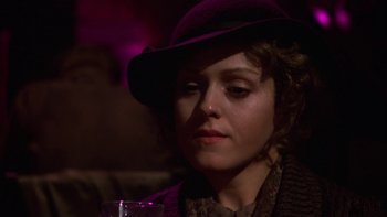 Movie still from “Pennies from Heaven” (1981), directed by Herbert Ross – A woman wearing a purple hat is sitting at a table; Close Up shot, Over the shoulder angle