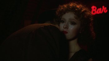 Movie still from “Pennies from Heaven” (1981), directed by Herbert Ross – A woman with red curly hair is sitting on a couch; Close Up shot, Over the shoulder angle