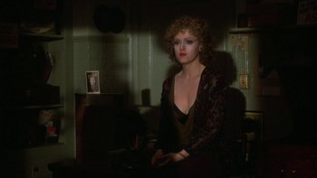 Movie still from “Pennies from Heaven” (1981), directed by Herbert Ross – A woman sitting at a desk in a dark room; Medium shot, Over the shoulder angle