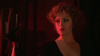 Movie still from “Pennies from Heaven” (1981), directed by Herbert Ross – A woman with curly hair is standing in a dark room; Close Up shot, Low angle