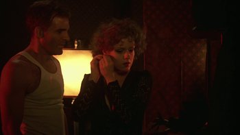 Movie still from “Pennies from Heaven” (1981), directed by Herbert Ross – A woman with red curly hair putting on a pair of earrings; Close Up shot, Over the shoulder angle