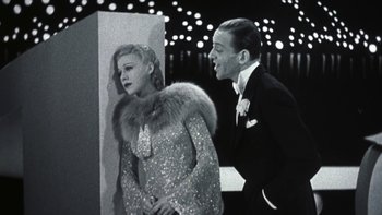 Movie still from “Pennies from Heaven” (1981), directed by Herbert Ross – A man and a woman standing next to each other in front of a wall; Medium shot, Low angle