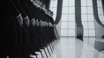 Movie still from “Pennies from Heaven” (1981), directed by Herbert Ross – A row of people in black suits holding canes; Wide shot, High angle