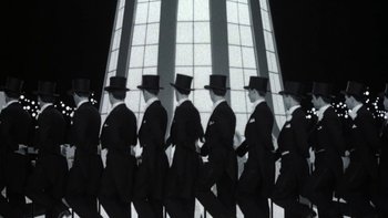 Movie still from “Pennies from Heaven” (1981), directed by Herbert Ross – A black and white photo of a group of men in tuxedos and top hats; Wide shot, Low angle
