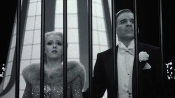 Movie still from “Pennies from Heaven” (1981), directed by Herbert Ross – A man and a woman standing next to each other in front of bars; Medium shot, Low angle