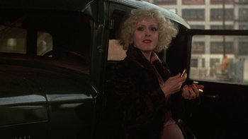 Movie still from “Pennies from Heaven” (1981), directed by Herbert Ross – A woman with a blonde curly hair sitting in the back of a car; Close Up shot, Over the shoulder angle