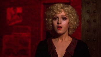 Movie still from “Pennies from Heaven” (1981), directed by Herbert Ross – A woman with blonde curly hair wearing a black shirt; Close Up shot, Low angle