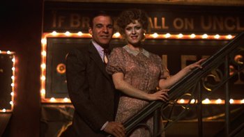 Movie still from “Pennies from Heaven” (1981), directed by Herbert Ross – A man and a woman standing next to each other; Medium shot, Low angle