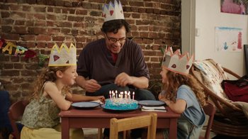 Movie still from “People Places Things” (2015), directed by Jim Strouse – A man sitting at a table in front of a birthday cake; Medium shot, High angle