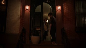 Movie still from “People Places Things” (2015), directed by Jim Strouse – A man and a woman standing in front of an open door; Wide shot, Over the shoulder angle