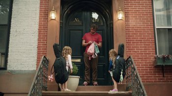 Movie still from “People Places Things” (2015), directed by Jim Strouse – A man and three children are standing on the steps; Wide shot, Over the shoulder angle
