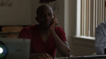 Movie still from “People Places Things” (2015), directed by Jim Strouse – A man sitting in front of a computer in front of a window; Close Up shot, Over the shoulder angle