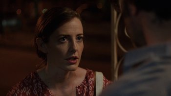 Movie still from “People Places Things” (2015), directed by Jim Strouse – A woman in a red and white dress looking at a man in a white shirt; Close Up shot, Over the shoulder angle
