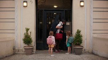 Movie still from “People Places Things” (2015), directed by Jim Strouse – A man and two little girls standing in front of a building; Wide shot, Over the shoulder angle