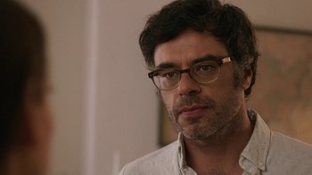 Movie still from “People Places Things” (2015), directed by Jim Strouse – A person wearing glasses and a white shirt; Close Up shot, Over the shoulder angle