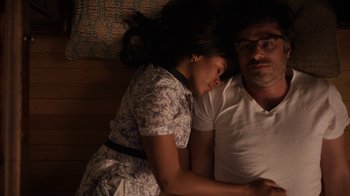 Movie still from “People Places Things” (2015), directed by Jim Strouse – A man and a woman laying on a bed; Medium shot, Overhead angle