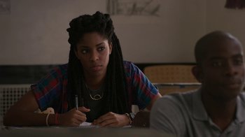 Movie still from “People Places Things” (2015), directed by Jim Strouse – A woman with dreads writing on a piece of paper; Close Up shot, Over the shoulder angle