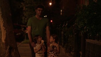Movie still from “People Places Things” (2015), directed by Jim Strouse – A man and two children eating ice cream; Medium shot, Over the shoulder angle