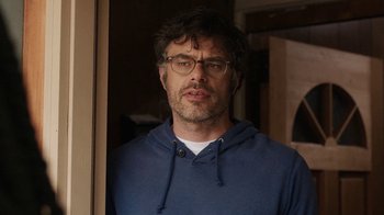Movie still from “People Places Things” (2015), directed by Jim Strouse – A person wearing glasses and a blue shirt; Close Up shot, Over the shoulder angle