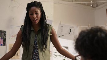 Movie still from “People Places Things” (2015), directed by Jim Strouse – A woman with long dreadlocks standing in a room; Medium shot, Over the shoulder angle