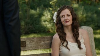 Movie still from “People Places Things” (2015), directed by Jim Strouse – A woman sitting on top of a wooden park bench; Close Up shot, Over the shoulder angle