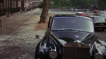 Movie still from “Performance” (1970), directed by Donald Cammell – An old car parked on the side of the street; Wide shot, High angle