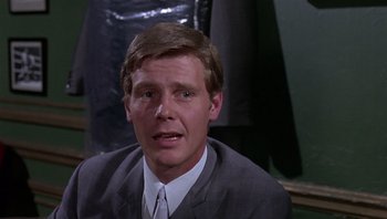 Movie still from “Performance” (1970), directed by Donald Cammell – A person wearing a suit and tie; Close Up shot, Low angle