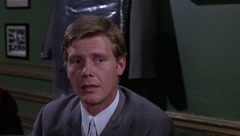 Movie still from “Performance” (1970), directed by Donald Cammell – A person wearing a suit and tie; Close Up shot, Low angle
