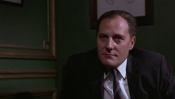 Movie still from “Performance” (1970), directed by Donald Cammell – A person wearing a suit and tie; Close Up shot, Low angle