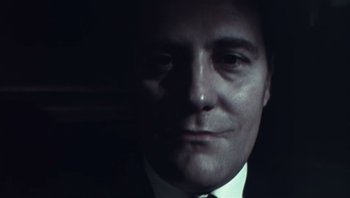Movie still from “Performance” (1970), directed by Donald Cammell – A person wearing a suit and tie; Close Up shot, Low angle