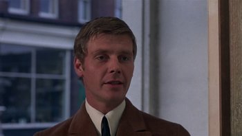 Movie still from “Performance” (1970), directed by Donald Cammell – A person wearing a suit and tie; Close Up shot, Over the shoulder angle